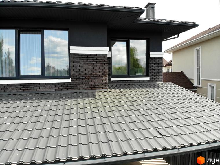 Котеджне містечко Kulbaba Petropavlivka: будинок з темно-сірим фасадом, цегляною обробкою та сірою металочерепицею на даху.