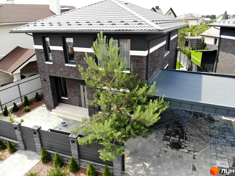 Котеджне містечко Kulbaba Petropavlivka: двоповерховий будинок з темно-сірою цегляною кладкою та світлим дахом, бруківка та сосна на подвір'ї.