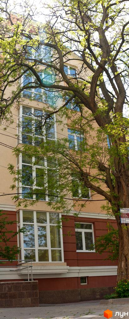 Зовнішній вигляд будинку на вул. Шкільна, 69, з великими вікнами та прибудинковою територією, оточеною зеленими насадженнями.