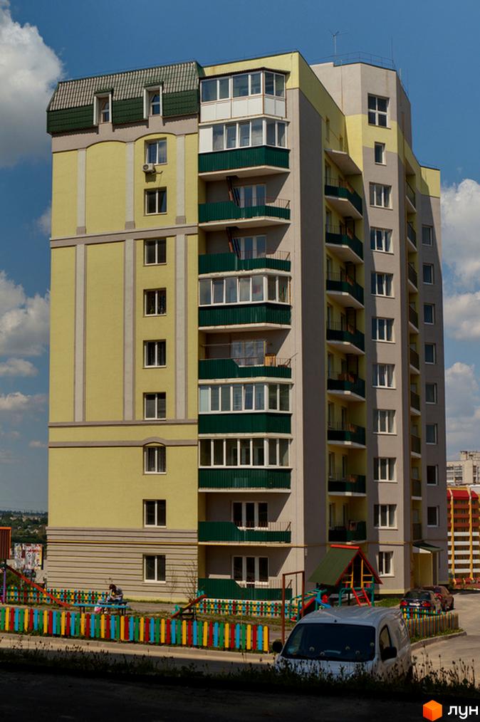 Житловий комплекс на вул. Черняка, 26-28 з жовтою фасадною обробкою та зеленими балконами. Прибудинкова територія з дитячим майданчиком та паркуванням.