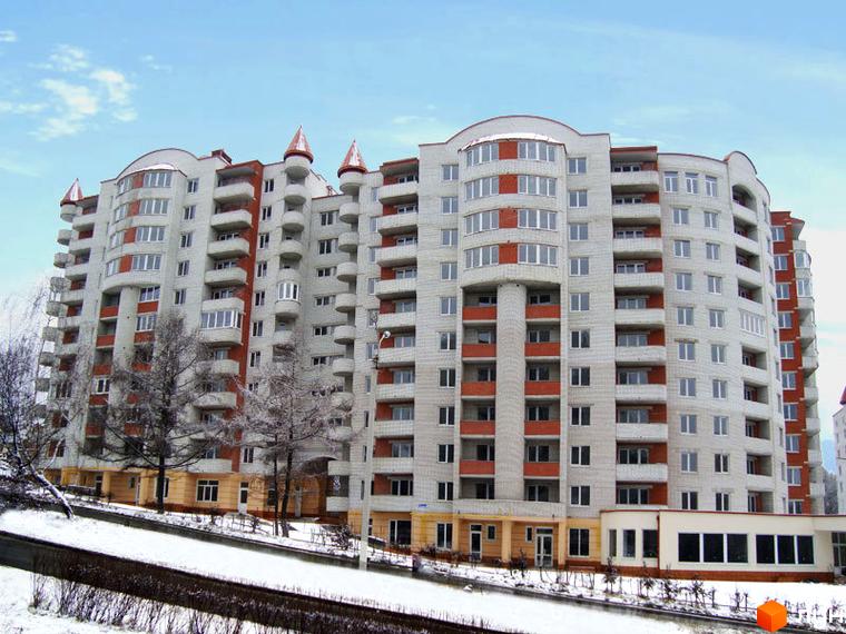 Житловий комплекс на вул. Коновальця, 11 з сучасним фасадом та балконами. Прибудинкова територія з зеленими насадженнями та доріжками.