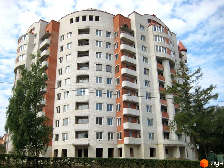 Житловий комплекс на вул. Коновальця, 15, з сучасною архітектурою та прибудинковою територією з зеленими насадженнями.