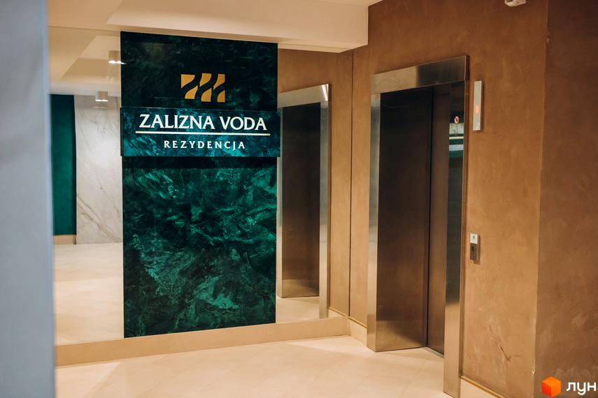 Клубний будинок Rezydencja „Zalizna Voda” з елегантною зеленою мармуровою колоною та сучасними ліфтами. Стильний інтер'єр холу новобудови.