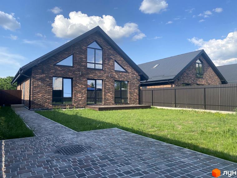 Котеджне містечко КМ Одноповерховий Київ - Білогородка. Фасад будинку з коричневої цегли, великі вікна, зелена галявина та вимощена доріжка.