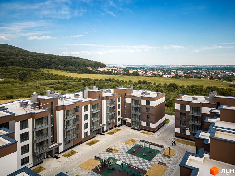 Новобудова ЖК Royal Hill з коричнево-білими фасадами та великими вікнами, поруч дитячий майданчик та зони відпочинку.