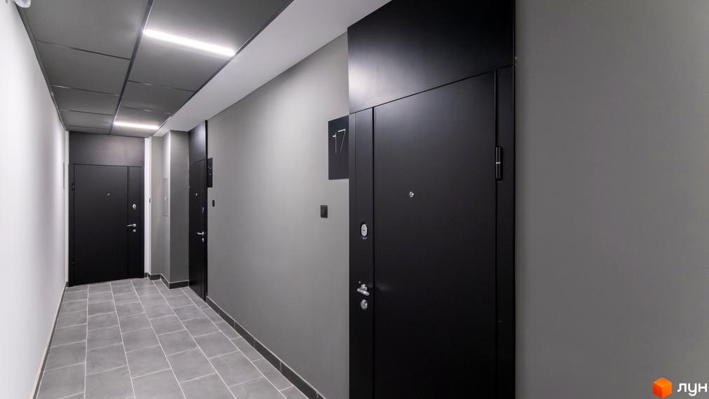 Коридор з дверима в ЖК Royal Hill. Сучасний дизайн з сірими стінами та плитковою підлогою.