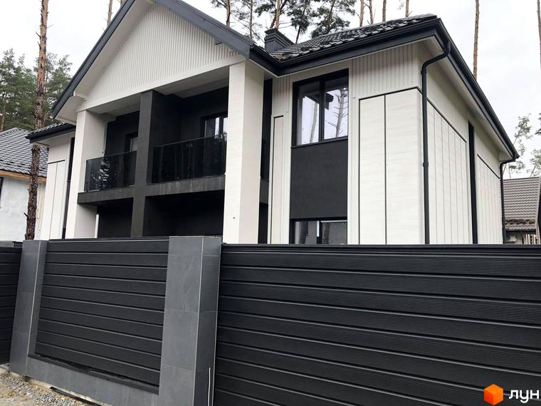 Фасад дуплексів Toscana Home з білими та темними елементами, великими вікнами та скляними балконами, огороджений чорним парканом.