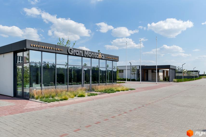 Зображення будівлі Котеджного містечка Gran Montana з панорамними вікнами та благоустроєм території. Вигляд на вхід та парковку.