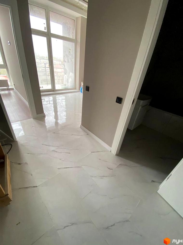 Клубний будинок Graf на Педагогічній. Фото інтер'єру з білою плиткою на підлозі та великими вікнами.