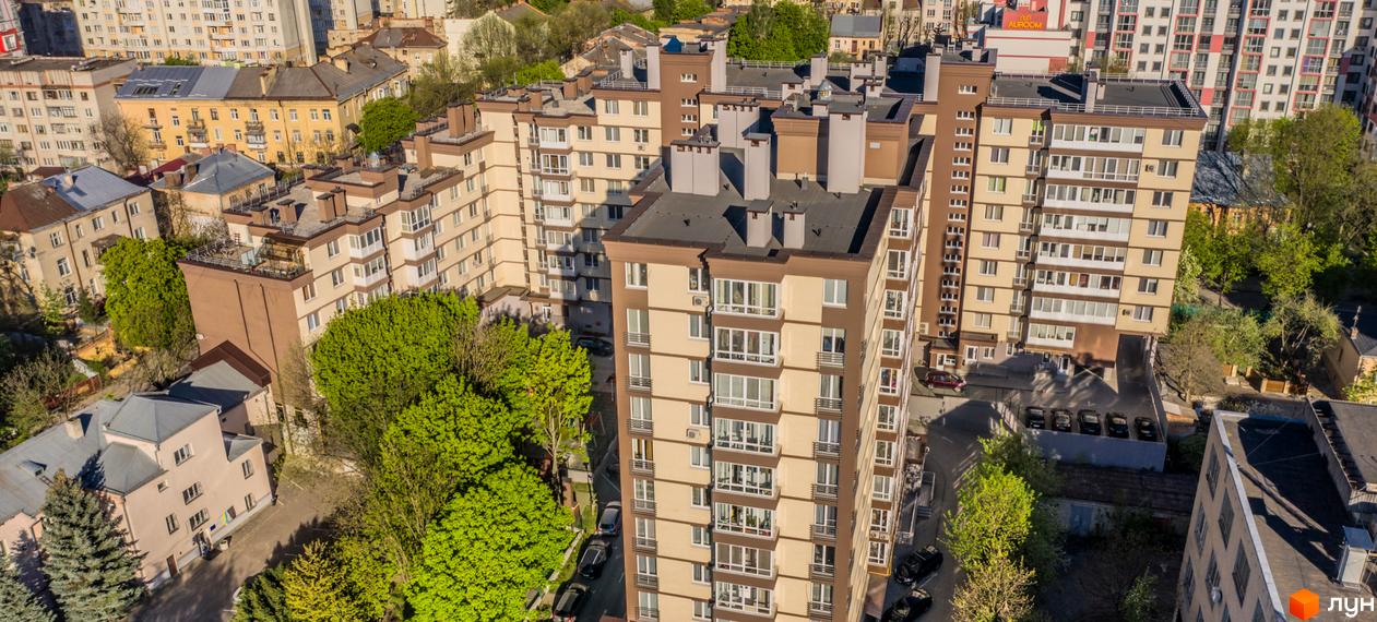 Житловий комплекс Шоколад: багатоповерхові будинки бежево-коричневого кольору з вікнами та балконами. Територія озеленена деревами, є парковки.