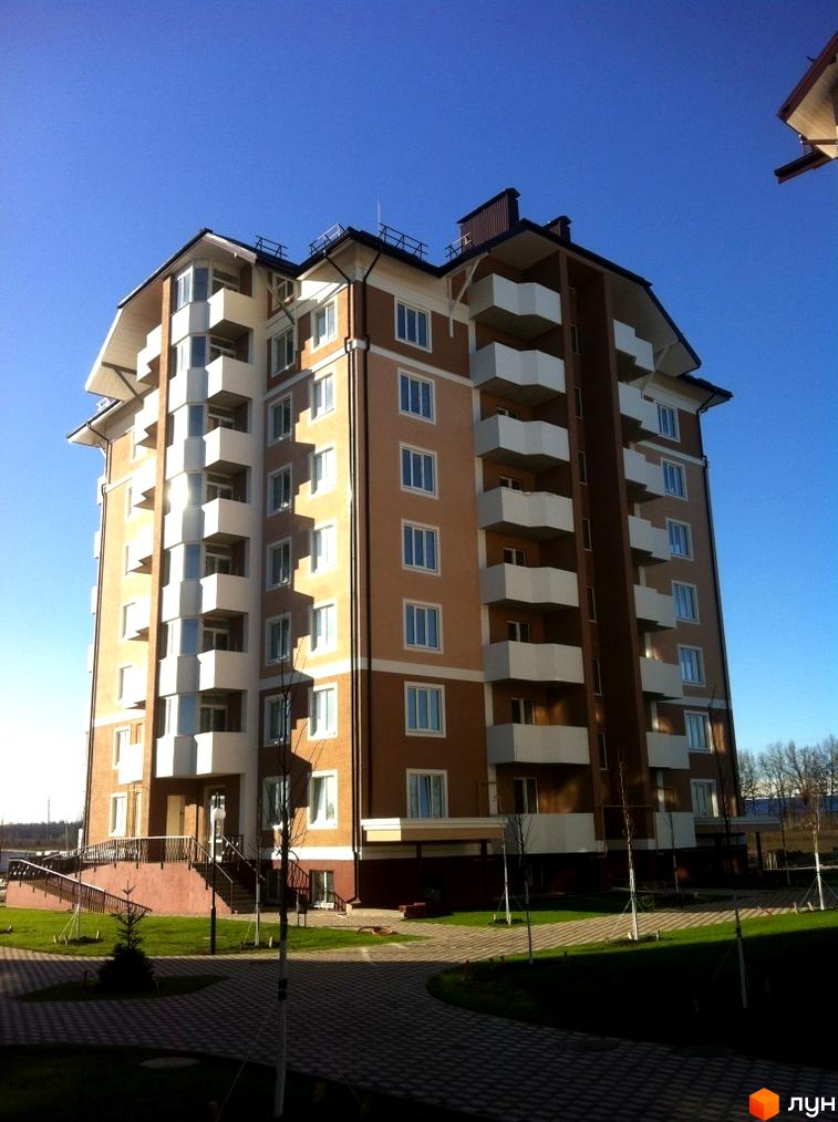 Житловий комплекс Квартал Буча з фасадом та балконами, прибудинкова територія з зеленими насадженнями та пішохідними доріжками.