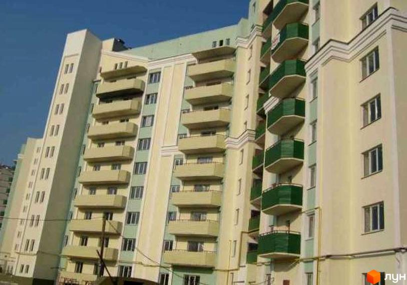 Житловий комплекс на проспекті Тракторобудівників, 103г з балконами та світлими фасадами. Прибудинкова територія облаштована для комфортного проживання.