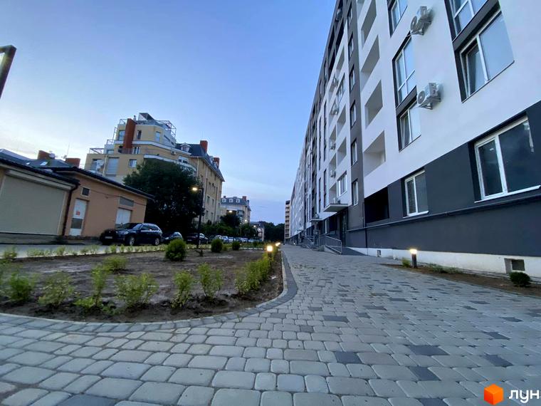 Житловий комплекс Щасливий: фасади будівель та вимощена алея з освітленням. Зовнішній вигляд новобудови та прибудинкова територія.