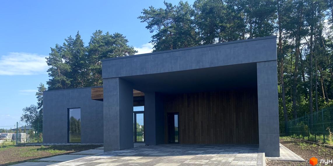 Зовнішній вигляд Котеджного містечка Нова Конча-Заспа CRYSTAL. Будівля з сірими стінами та великими вікнами, поруч дерева.