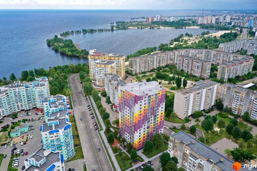 Житловий комплекс Парковий на Дніпрі - вид з висоти пташиного польоту на багатоповерхові будинки з яскравим фасадом та зелену прибудинкову територію.