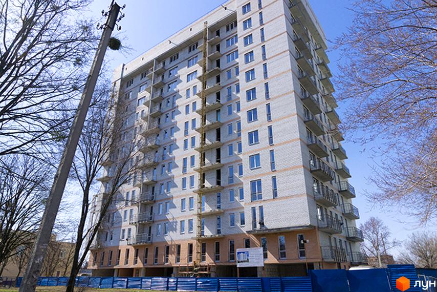 Будівельний проєкт на просп. Петра Григоренка, 18а. Багатоповерховий будинок з балконами та вікнами на тлі блакитного неба та дерев.