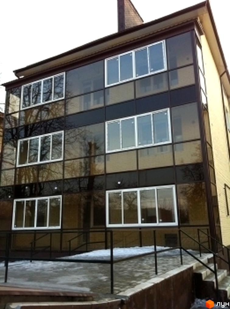 Житловий комплекс на вул. Підлісна, 15 з сучасним фасадом та великими вікнами. Прибудинкова територія з пішохідними доріжками та зеленими насадженнями.