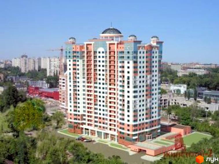 Житловий комплекс Будинок із Ротондами – висотна будівля з білими та рожевими фасадами, скляними елементами та куполами. Навколо – зелена прибудинкова територія з газонами та деревами.