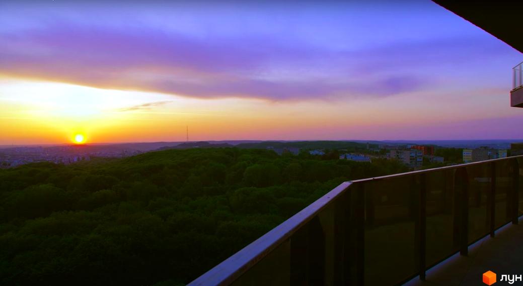 Вид на житловий комплекс Tiffany з балкона на заході сонця. Зелена прибудинкова територія та міський пейзаж.