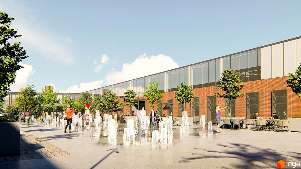 Житловий комплекс РЕМ має цегляний фасад та великі вікна. Перед ним розташована площа з фонтанами, деревами та людьми, що відпочивають.