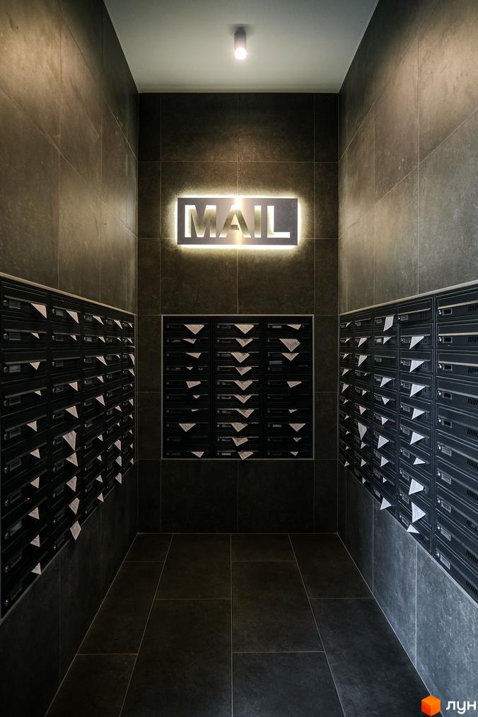 Внутрішній простір Житлового комплексу Гранд Бурже: коридор з численними поштовими скриньками та світловою вивіскою MAIL.