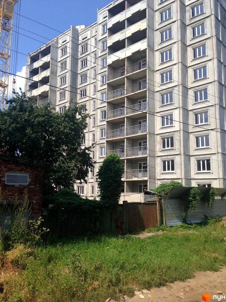 Будівля житлового комплексу Софіївський з балконами та великими вікнами, оточена зеленими насадженнями та прибудинковою територією.