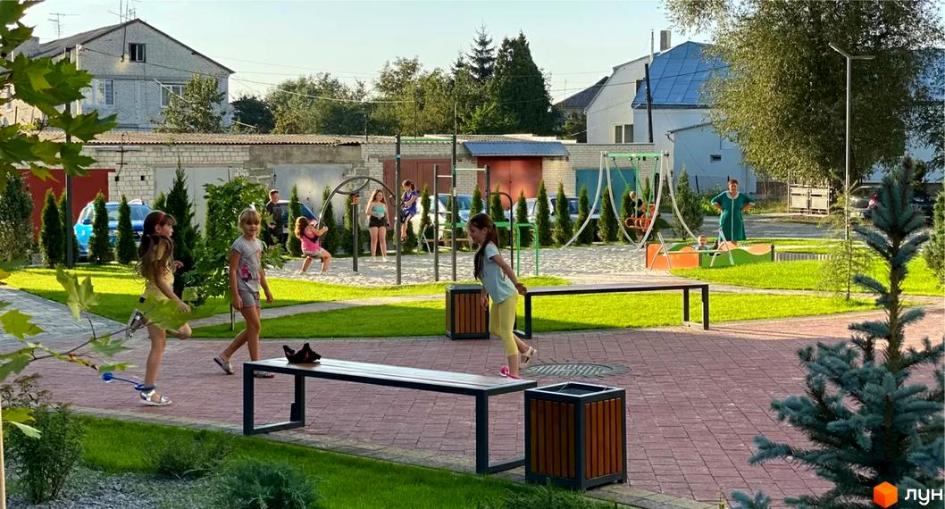 Житловий комплекс Місто Комфорту на Лісневицькій: вигляд будинку та дитячий майданчик на прибудинковій території.