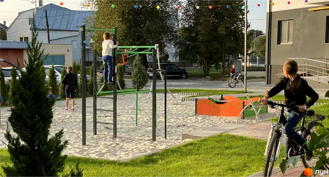 Зображення дитячого майданчика біля Житлового району Місто Комфорту на Лісневицькій. На фото видно ігровий комплекс та дітей на території.