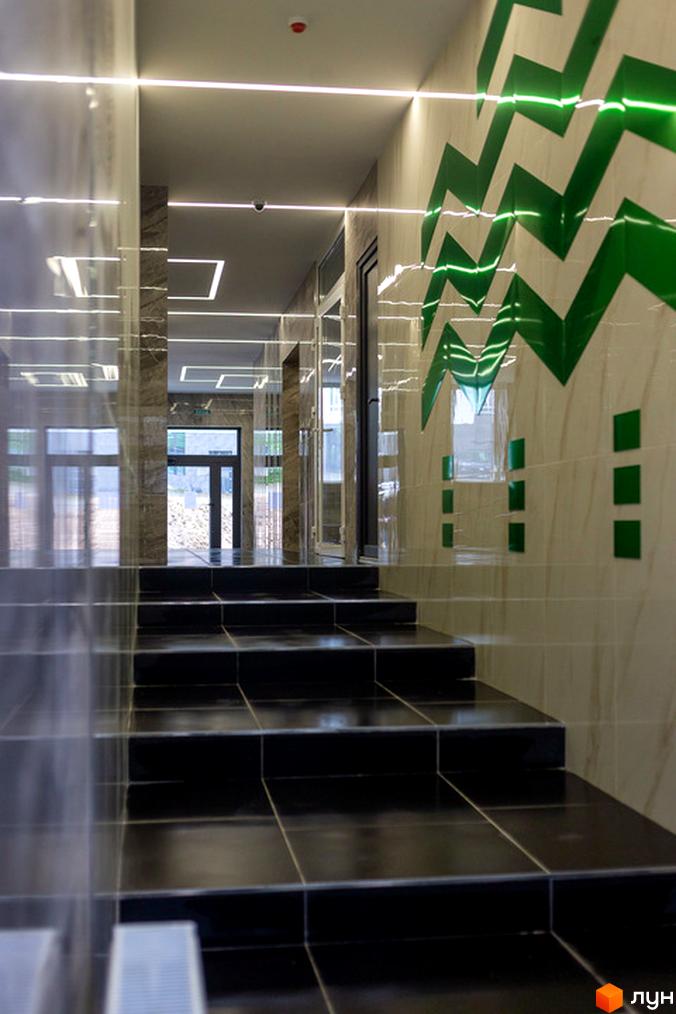 Сходи вхідної групи ЖК City Park з мармуровими стінами та зеленим декором. Сучасний дизайн інтер'єру новобудови.