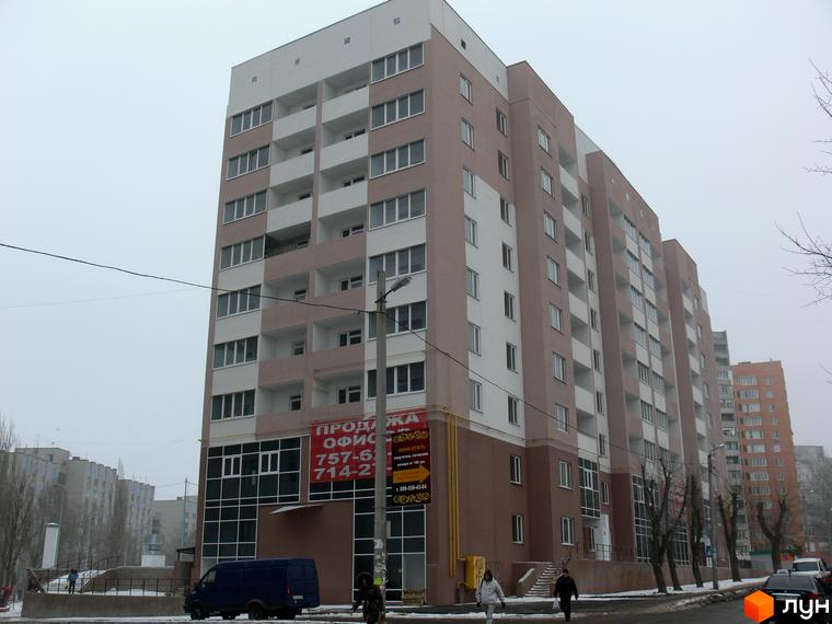 Житловий комплекс Супутник з фасадом, вікнами та прибудинковою територією. Вид на будинок з пішохідною зоною та автомобілями.