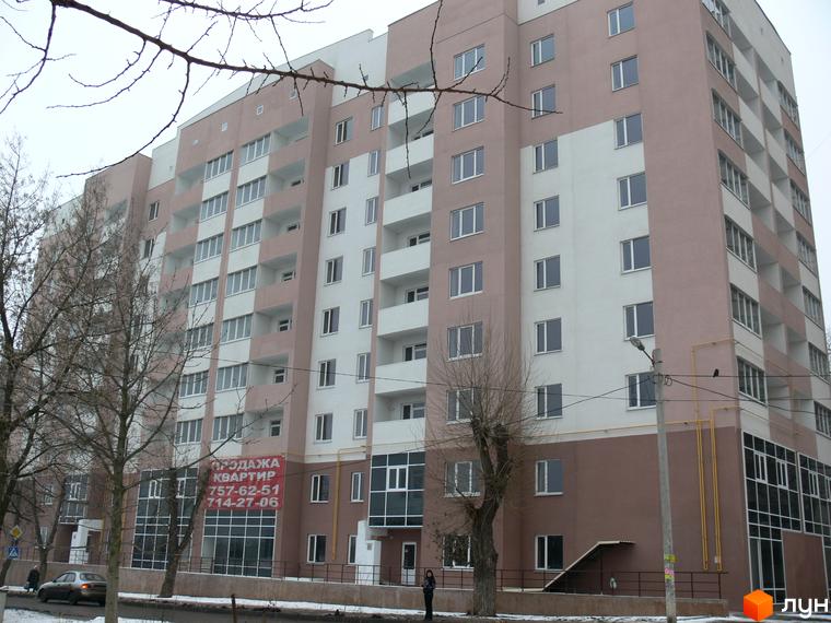 Зовнішній вигляд багатоповерхового житлового комплексу Супутник з рожевим та білим фасадом. На першому поверсі видно комерційні приміщення та вхідні групи.