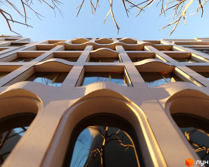 Фасад житлового комплексу Residence Eleven з арковими вікнами та хвилястими елементами. Вид знизу на тлі блакитного неба та гілок дерев.