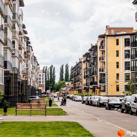 Житловий комплекс Кришталеві джерела: фасади багатоповерхових будинків з балконами та прибудинкова територія з паркуванням та зеленою зоною.