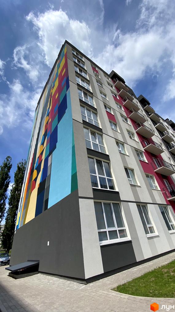Житловий комплекс Синергія Color з яскравим фасадом та вікнами, що виходять на зелену зону та бруківку.