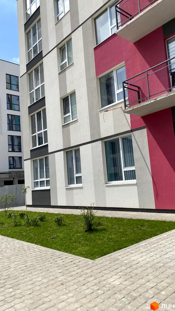 Житловий комплекс Синергія Color: фасади будівель з пастельними кольорами та балконами, зелена зона з доріжками.