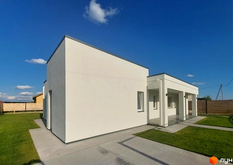 Котеджне містечко КМ Лісне: білий двоповерховий будинок з терасою та зеленим газоном навколо.