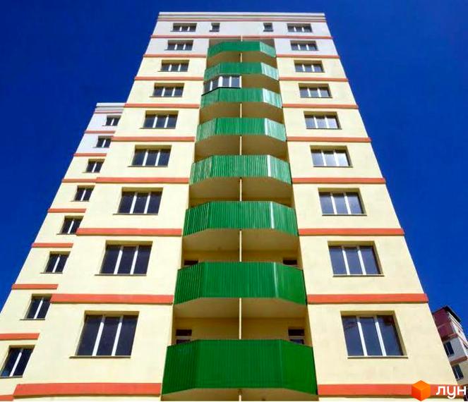 Житловий комплекс ЖБК Новий дім Котлова з фасадом жовтого кольору та зеленими балконами. На фоні ясне синє небо.