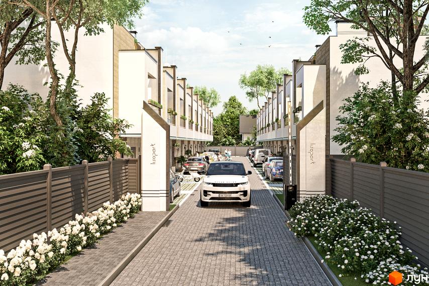 Таунхауси Lisopark. В'їзд на територію житлового комплексу з парканом, клумбами та паркомісцями.