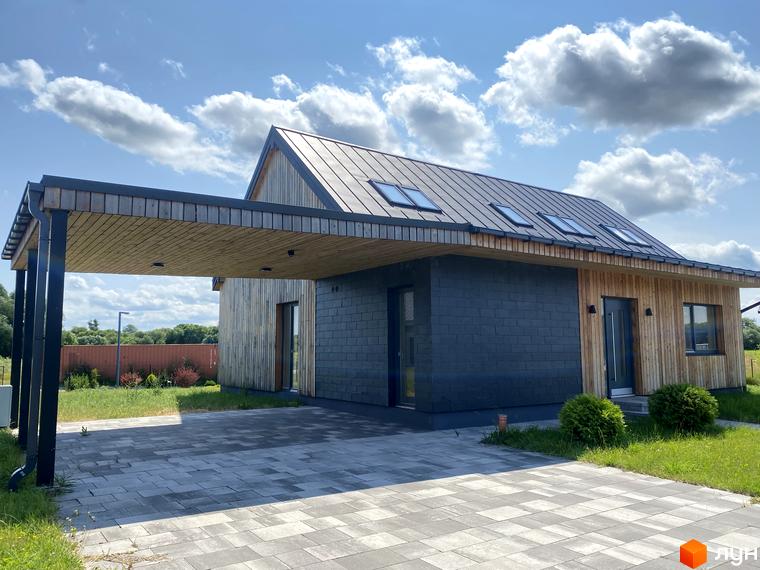 Зображення будинку Котеджного містечка Mulberry Homes. Будинок з темною покрівлею та облицюванням стін деревом та темною плиткою. Перед будинком розташована брукована доріжка та газон.