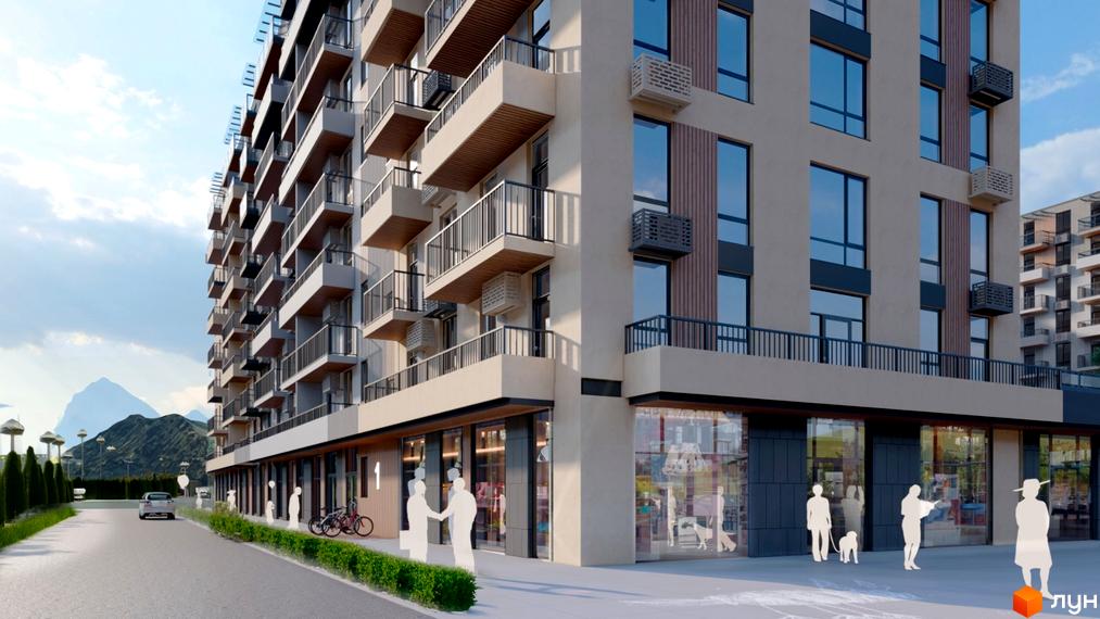 Житловий комплекс КОРОНА з балконами та панорамними вікнами. На першому поверсі розташовані магазини. Поруч зелені насадження та дорога.