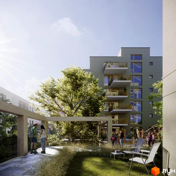 Житловий комплекс HYGGE LUX з балконами та великими вікнами на тлі зеленого дерева та дитячого майданчика.