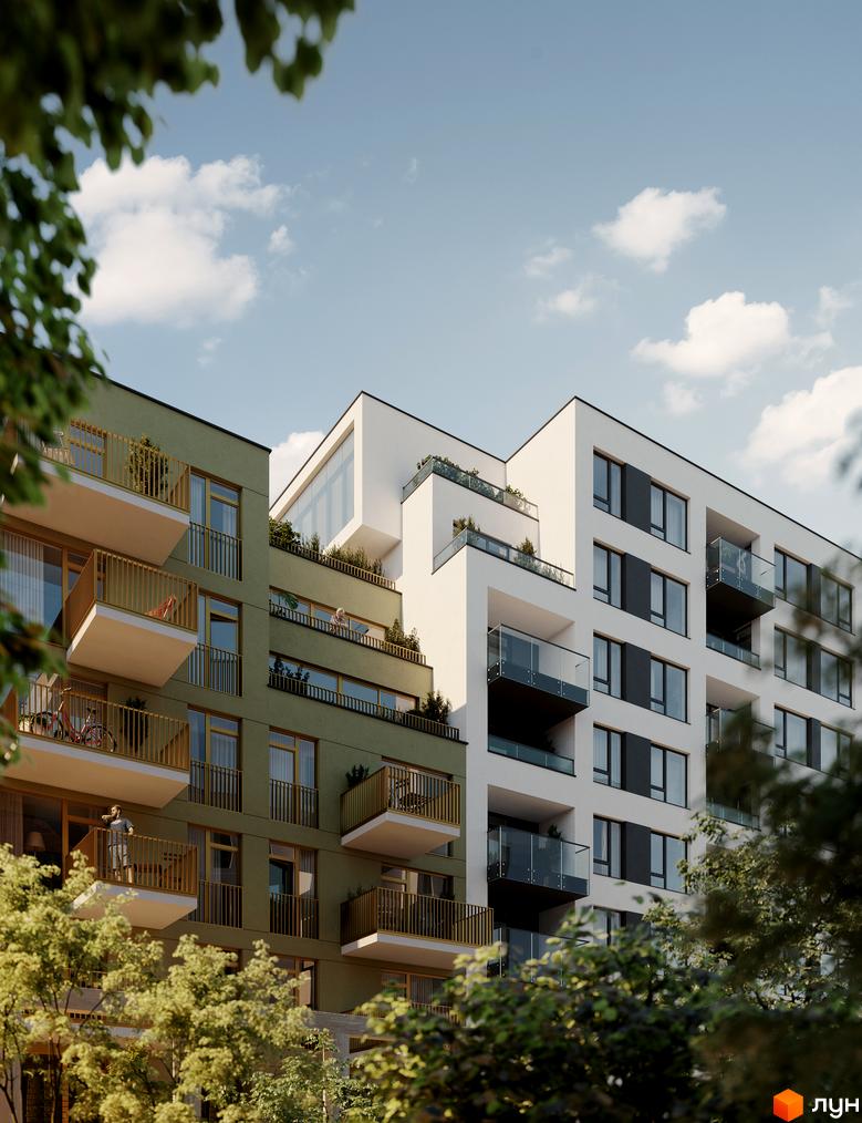 Новобудова HYGGE LUX з зеленим фасадом та білими блоками, балконами зі скляними огорожами та деревами на прибудинковій території.