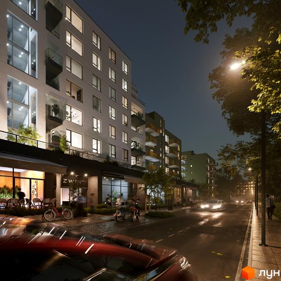 Житловий комплекс HYGGE LUX вночі з освітленими вікнами та балконами, з вулицею та деревами на передньому плані.