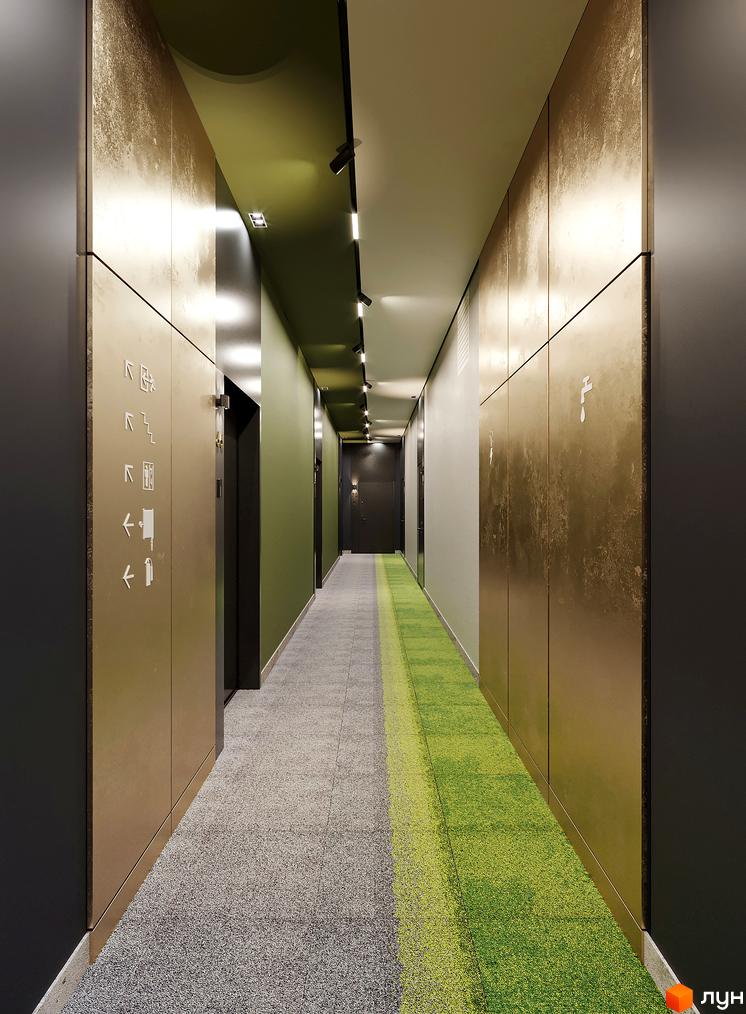 Інтер'єр коридору Житлового комплексу PERFECT LIFE: стіни з бронзовими панелями та зеленим акцентом, двоколірний килим.