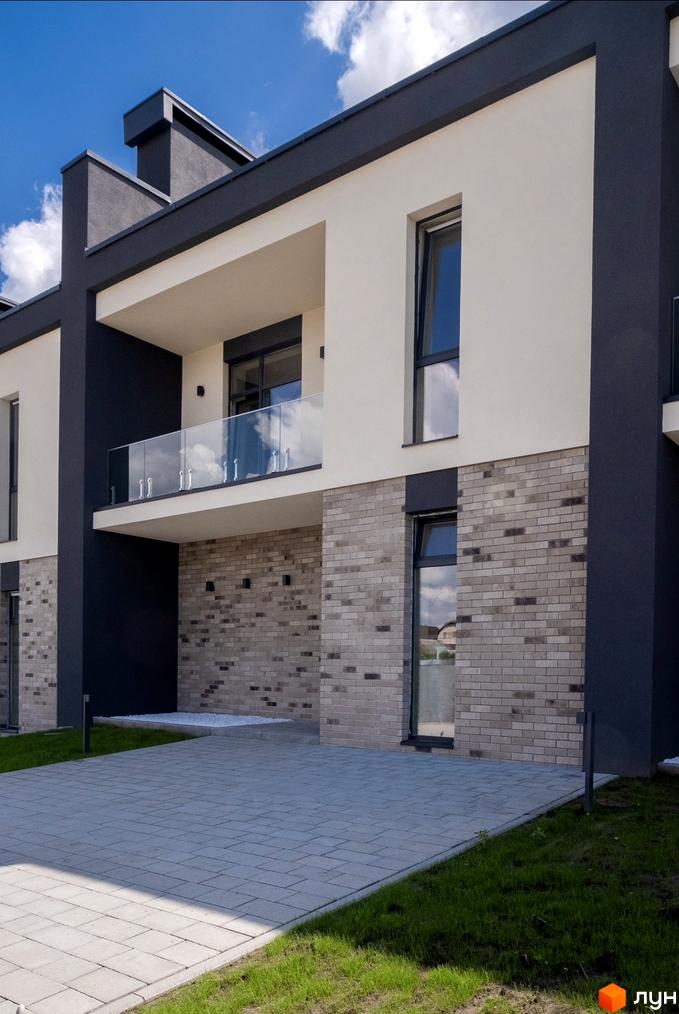 Котеджне містечко Квадрат TOWN: двоповерховий будинок зі світлим фасадом, сірою цеглою, темними вікнами, скляним балконом та вимощеною доріжкою.