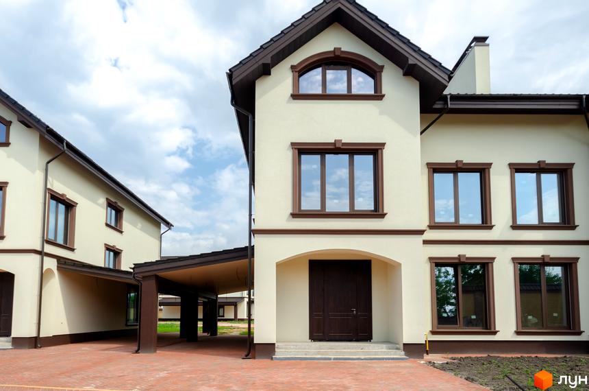 Котеджне містечко КМ Vita Energy residence - фасади будинків з коричневими вікнами та дверними отворами, прибудинкова територія з бруківкою та навісами.