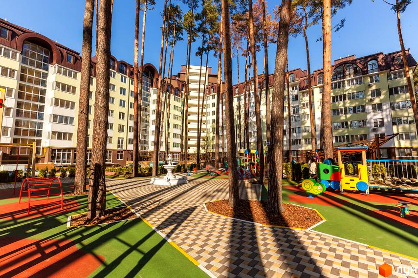 Житловий комплекс Ірпінські Липки з сучасними фасадами та прибудинковою територією, облаштованою для відпочинку.