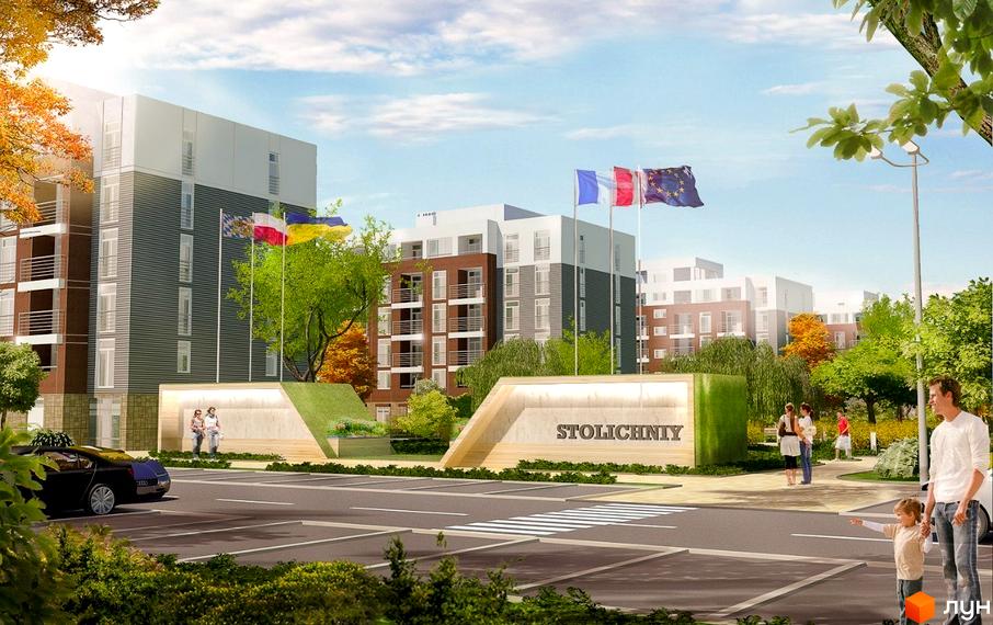 Житловий комплекс Столичний. Фасади будинків з цегли та сірого кольору, з балконами. Прибудинкова територія з дорогою, парковкою та прапорами.