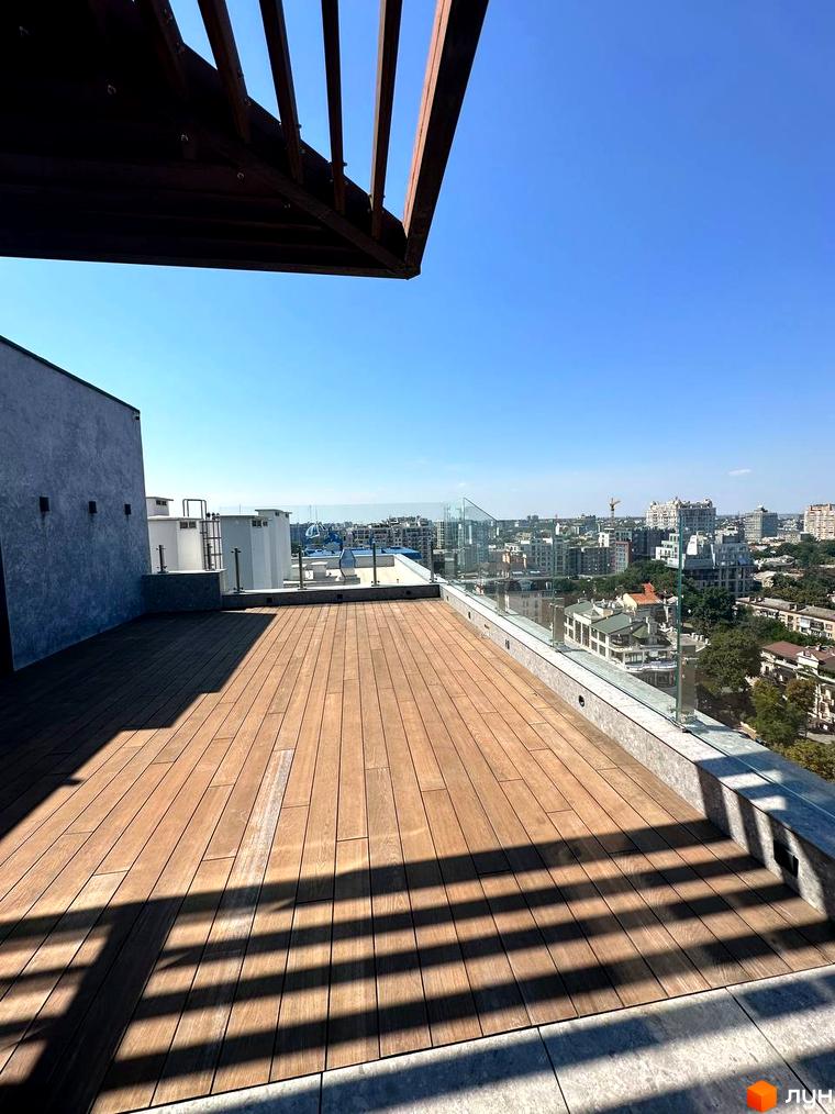 Клубний будинок Graf. Вид з тераси на місто. Тераса з дерев'яним покриттям та скляним огородженням.