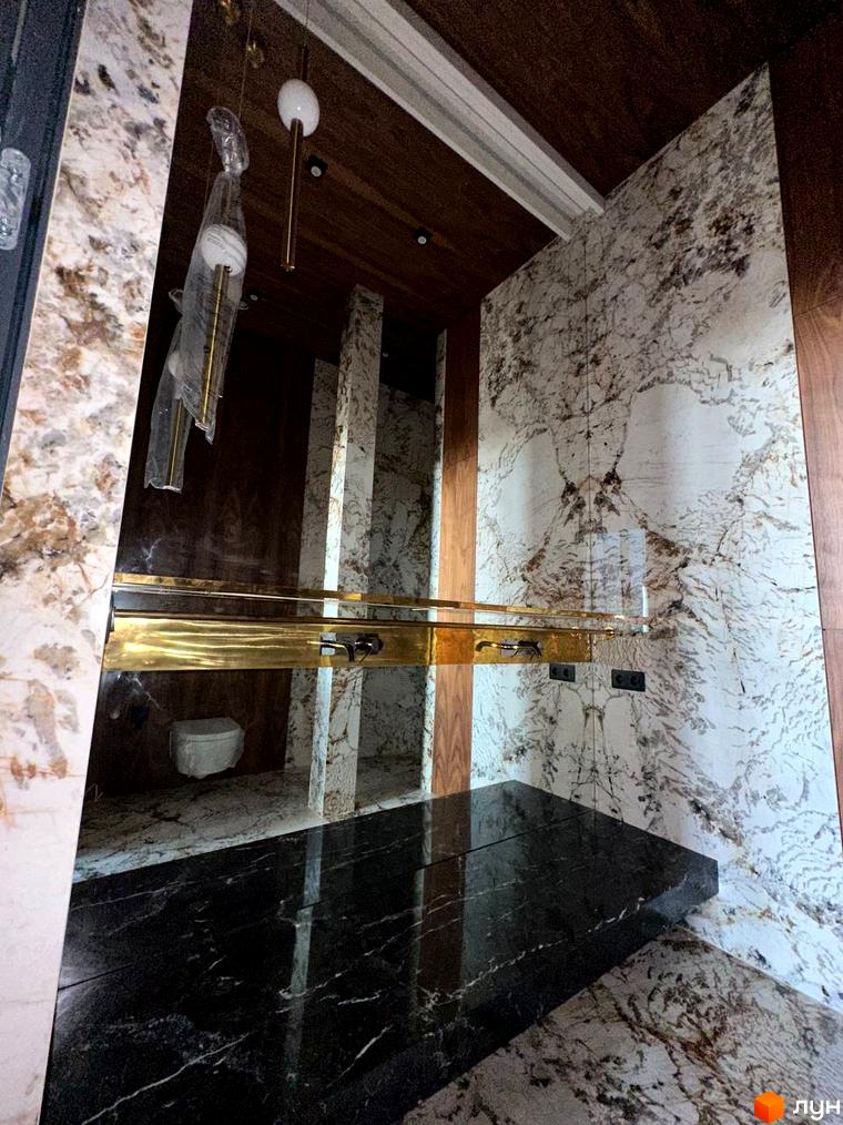 Інтер'єр ванної кімнати у клубному будинку Graf з мармуровим оздобленням та золотими елементами. Сучасний дизайн та високоякісні матеріали для вашого комфорту.